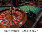 Casino, gambling and entertainment concept - roulette table and stack of poker chips