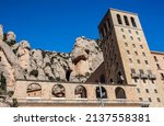 Santa Maria de Montserrat Abbey with Mountain Rock and Blue Sky. Beautiful View of Building Facade in Catalonia.