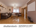 Small photo of Living room furnished with somewhat kitschy decoration with wooden coffee tables and two twin corner sofas upholstered in brown fabric