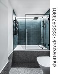 Small photo of a modern designer toilet with a bathtub with a tempered glass screen, green tiles, black details and gray terrazzo floors