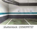 Small photo of An empty underground car park delimited by white and green paint on the concrete floor on non-slip paint
