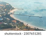Small photo of View of new Con Dao passenger port in Con Son town, a peaceful Con Dao island, Vietnam. Coastal view with waves, coastline, clear sky, blue sea, tourists and mountain. Travel and landscape concept.