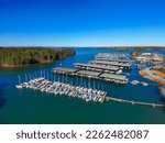 Small photo of Boats and yachts docked and sailing in the marina on Lake Lanier with lush green trees and and a gorgeous clear blue sky in Cummings Georgia USA