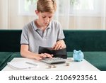 Small photo of Kid teen boy counting money and taking notes, saving money in a piggy bank. Learning financial responsibility and projecting savings. Concept of finance, business, investment. Lessons in mindfulness