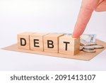 Small photo of wooden blocks with word Debt. reduction or restructuring of debt. refusal to pay debts or loans and invalidate them