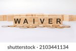 Small photo of waiver concept, wooden word block on grey background