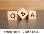 text q and a on wooden blocks against brown background with copy space. concept of sale and discount.