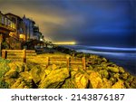 Houses on the coast in the late evening. Coastline city houses in evening time. Evening on coastline. Evening coastline landscape