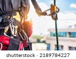 Concept of urban works. Equipment of industrial mountaineer worker on roof of building during industry high-rise work. Climbing equipments before starting job. Rope laborer access. Copy space