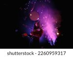 Small photo of Female magician illusionist circus showing soap bubbles show at black background. Woman actress in theatrical clothes with stylish hat in stage costume. Concept of theatre performance. Copy space