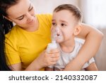 a little girl cries when inhaled with a nebulizer. A child with a viral disease in an inhalation mask is sitting in his mother's arms. Patient with asthma.