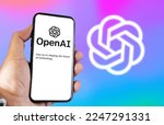 Small photo of San Francisco US, Dec 2022: A hand holding a phone with the OpenAI website on the screen. Colorful background with blurred logo. OpenAI is a non-profit artificial intelligence research organization.