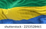 Small photo of The Gabon national flag waving in the wind. The Gabonese Republic is a Central African Country. Rippled fabric. Textured background. Realistic 3d render. Close-up