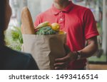 smart food delivery service man in red uniform handing fresh food to recipient and young woman customer receiving order from courier at home, express delivery, food delivery, online shopping concept 