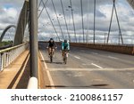 Small photo of BRASILIA FEDERAL DISTRICT BRAZIL – DECEMBER 26 2021:Two cyclists crossing the JK bridge in Brasilia.