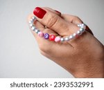 Selective focus. Friendship bracelets made of handmade plastic beads. Set of bright colorful braided bracelets with words. Colored ts teen jewelry.