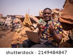 African boy at the market holding FCFA francs and a Bitcoin coin, implementation of cryptocurrencies in africa