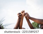 Four fists of African people united in sky, photo with copy space above