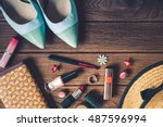 women's accessories - bag, heels, earrings, nail polish, lipstick on wooden background, top view