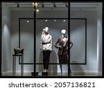 Shop windows and mannequins. Fashion Store exterior. City Night Boutique. Front View from street outdoor. LED light. City facade background