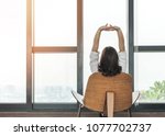 Living lifestyle, luxury simplicity home relaxation life style of happy working woman take it easy sitting resting on comfort chair at home, condominium or city hotel lobby interior with rooftop view