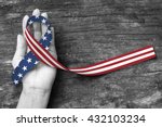 American flag pattern awareness ribbon on people's hand (isolated with clipping path) for USA United Stated of America national support and POW/MIA recognition day concept