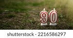 Small photo of Burning candles in the form of numbers 90. Candles set on the ground with the ninetieth anniversary. Congratulations on the anniversary.