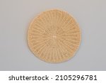 Small photo of Round woven placemat isolated on a grey background.