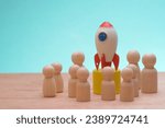 Small photo of The wooden figures, clustered around a symbolic rocket, epitomized the success strategy of a cohesive team, reflecting the collective effort of teammates propelling the company towards global business
