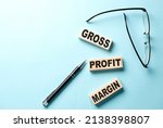 Small photo of GROSS PROFIT MARGIN text on wooden block ,blue background