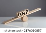 Small photo of GNP text on a wooden cubes on a wooden balance , business concept