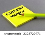 Small photo of EARNEST MONEY text written on sticky on grey background