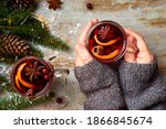 Woman hands hold cup of hot mulled wine