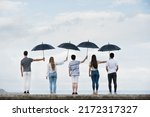 Small photo of Teamwork and sacrifice concept. Group of people covering each other with umbrellas