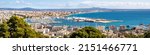 Wide panorama photography of the bay of Palma de Mallorca with commercial docks, marina, city, old town, cathedral La Seu, airport and beach Playa de Palma of El Arenal at the horizon in springtime.
