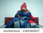 Bearded sick man with flue sitting on sofa at home or studio covered with knitted warm clothes. Illness, influenza, pain concept. Relaxation at Home. Healthcare Concepts.