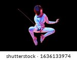 Small photo of Movement. Teen girl in fencing costume with sword in hand isolated on black background, neon light. Young model practicing and training in motion, action. Copyspace. Sport, youth, healthy lifestyle.