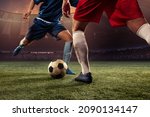 Small photo of Goalmouth scramble. Two male soccer, football players dribbling ball at the stadium during sport match at crowed stadium. Sport competition. Action, motion, fitness, energy and dynamic concept.