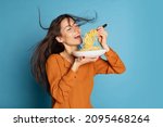 Small photo of Delicious taste. Beautiful young girl eating delicious Italian pasta isolated on blue studio background. Holidays, traditions, food, popularity, cafe, love. Healthy carbohydrates. Copy space for ad