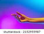 Small photo of Entreaty. Studio shot of aethentic human hand isolated on gradient purple-blue background in neon light. Concept of human relation, community, art, symbolism, culture and history
