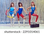 Small photo of Beautiful young women in blue and red sportswear training fit fitness equipments, doing stretching and aerobics exercises. Concept of retro fitness, sport, 80s fashion, beauty, health