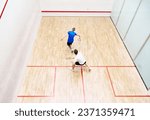 Top view of two young men, friends, sportsmen playing squash on squash court. Competition. Concept of sport, hobby, healthy and active lifestyle, game, gym, ad