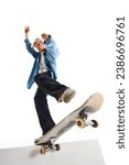 Small photo of Bottom view image of teen boy in casual clothes in motion, training, doing stunts on skateboard isolated over white background. Concept of professional sport, competition, training, action.