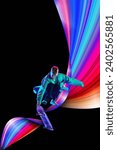 Small photo of Young man, sportsman doing stunts on skateboard against black background in neon lights with colorful abstract element. Creative design. Concept of creativity, art, sport, competition, training