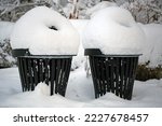 Snowy outdoor trash cans in a park in winter