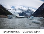 Laguna Torre lake with icebergs breaking away from glacier. Panoramic view of Cerro Torre mountain in clouds and glacier Torre. One day trek to Laguna Torre from El Chalten, Patagonia, Argentina