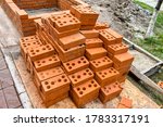 Small photo of A pile of red bricks at a construction site in the city. Reupload the wall of bricks with cement in construction. Repair, industrial brickwork parts, construction equipment.