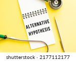 Small photo of ALTERNATIVE HYPOTHESIS is written in a notebook on a color table next to pen and a stethoscope. Medical concept