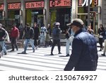 Small photo of New York, NY USA - April 21, 2022: New York City, New Yorkers in Midtown Manhattan Walking Masked and Unmasked During Year 2 of Covid-19 Pandemic