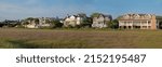 Small photo of SULLIVAN'S ISLAND, SC, USA - MAY 02, 2022: Panorama of ocean-front vacation rental properties, with a tidal marsh in the foreground, on Sullivan’s Island, SC.